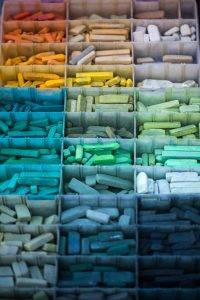 magnifique photo en macro des casiers de pastels classés par couleurs, bleu, rouge, vert, jaune, blanc