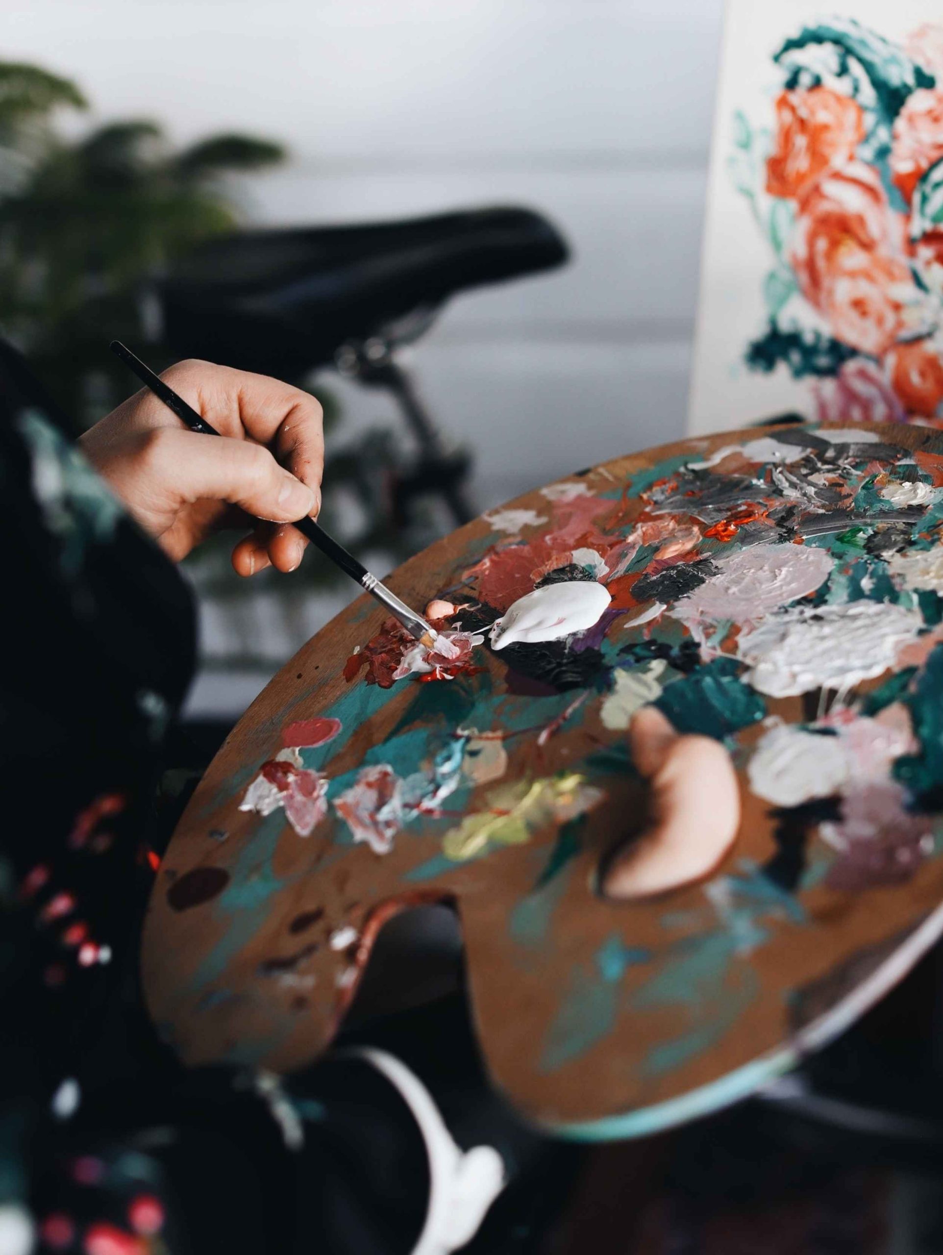 magnifique photo d'une palette de peinture, le peintre est en train de mélanger du blanc avec des couleurs